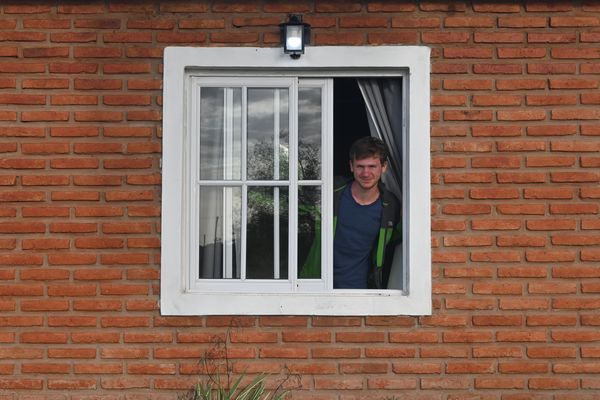 Pascal wirft einen Blick aus unserer Unterkunft durch ein Fenster.