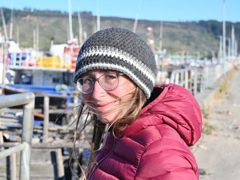 Anja steht im Hafen von Lebu und der Wind weht ihr die Haare ins Gesicht