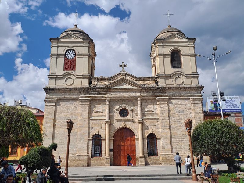 Eine Kirche am Hauptplatz, vor der sich tagsüber viele Leute aufhalten.