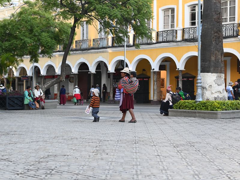 Traditionell gekleidete Mutter mit Kindern am Marktplatz.