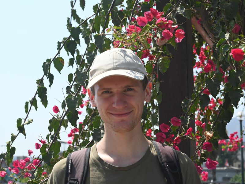 Pascal vor ein paar schönen Blumen.