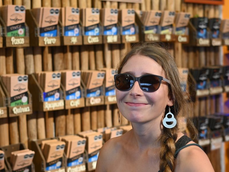 Anja steht vor einem Regal voll mit Schokoladentafeln im Choco-Museum.