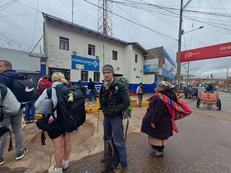 Pascal wartet vor dem Gebäude des Grenzübergangs auf seinen Peru Einreisestempel.