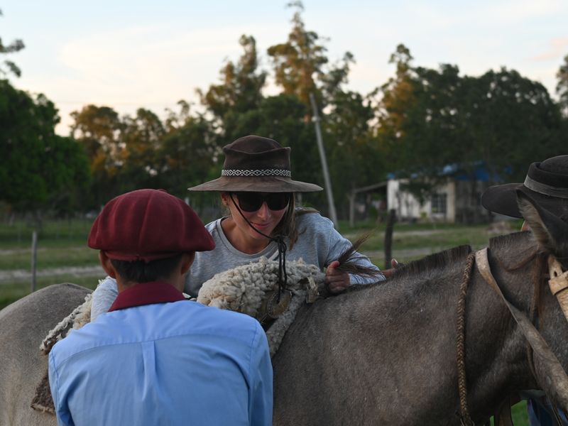 Anja sattelt auf ihrem Pferd auf.