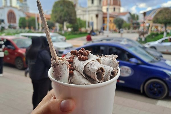 Ein Rolled Ice mit Löffel vor einer Kirche am Hauptlatz Huancayos.