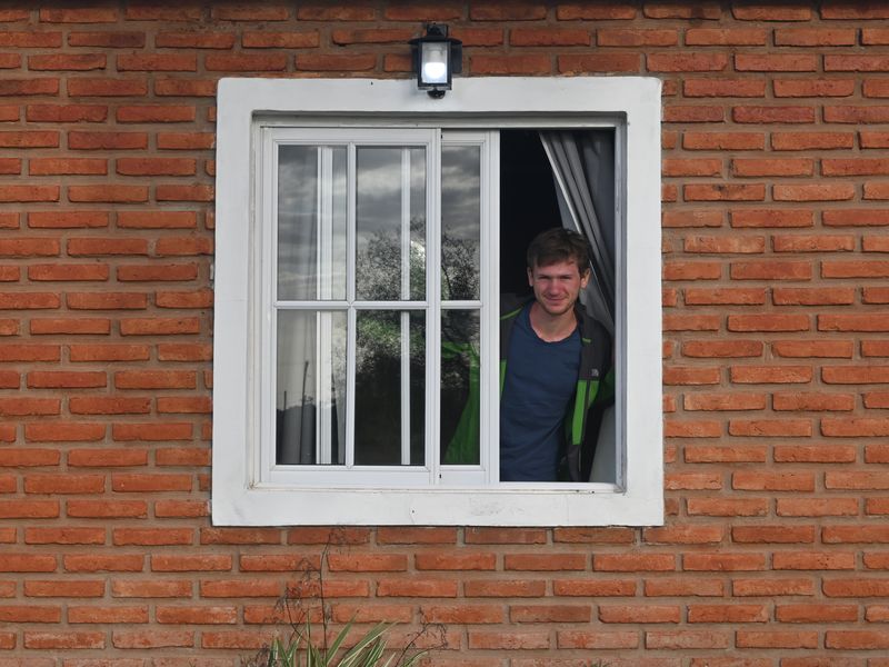 Pascal wirft einen Blick aus unserer Unterkunft durch ein Fenster.
